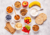 Help Your Kids Make Healthy Snack Choices A marble tabletop with a selection of fruits, vegetables, nuts, crackers, and dips.