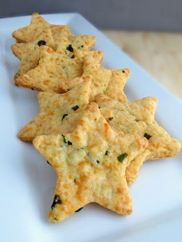 parmesan, basil, and cheddar stars laying in a line on a white plate.