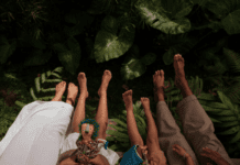 10 Parent-Friendly Tips For a Stress-Free Family Vacation A jungle type background with the legs of two adults and two children, from the thighs down, appearing from the bottom of the frame.