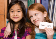 Sight Words that Every 1st Grader Should Know Two girls smiling and holding a card that says "WE"
