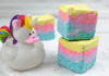 Homemade Unicorn Sugar Scrub Cubes Three, stacked, homemade Unicorn sugar scrub cubes with layers of teal, purple, pink, and yellow.