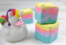 Homemade Unicorn Sugar Scrub Cubes Three, stacked, homemade Unicorn sugar scrub cubes with layers of teal, purple, pink, and yellow.