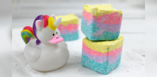 Homemade Unicorn Sugar Scrub Cubes Three, stacked, homemade Unicorn sugar scrub cubes with layers of teal, purple, pink, and yellow.