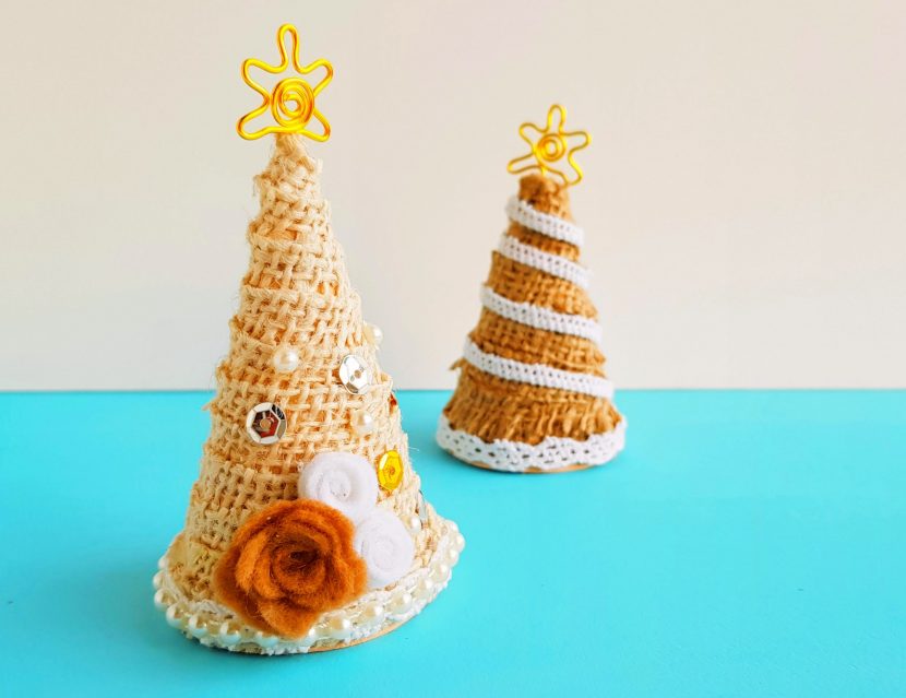 rustic Christmas tree craft made of carboard cone, hessian, felt, sequins, and other decorations.