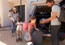 Summer Family Road Trip Essentials A family of two adults and two children are packing items into the back of a car for a road trip.