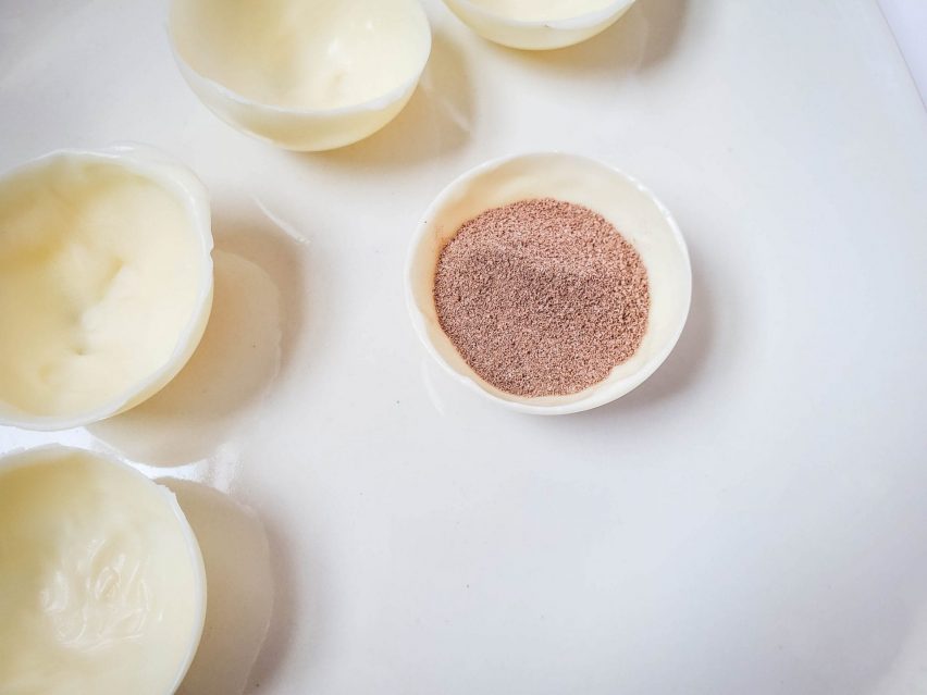 A white chocolate half-sphere filled with a tablespoon of milk chocolate cocoa mix.