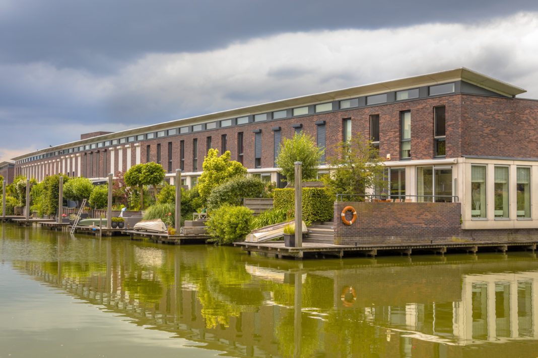 Modern houses with hanging terrace gardens on waterfront in urban area of The Hague, Netherlands