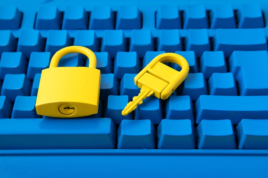 Cyber data and information security idea. Yellow padlock and key and blue keyboard. Computer, information safety, confidentiality concept. Top view, flat lay, mock up