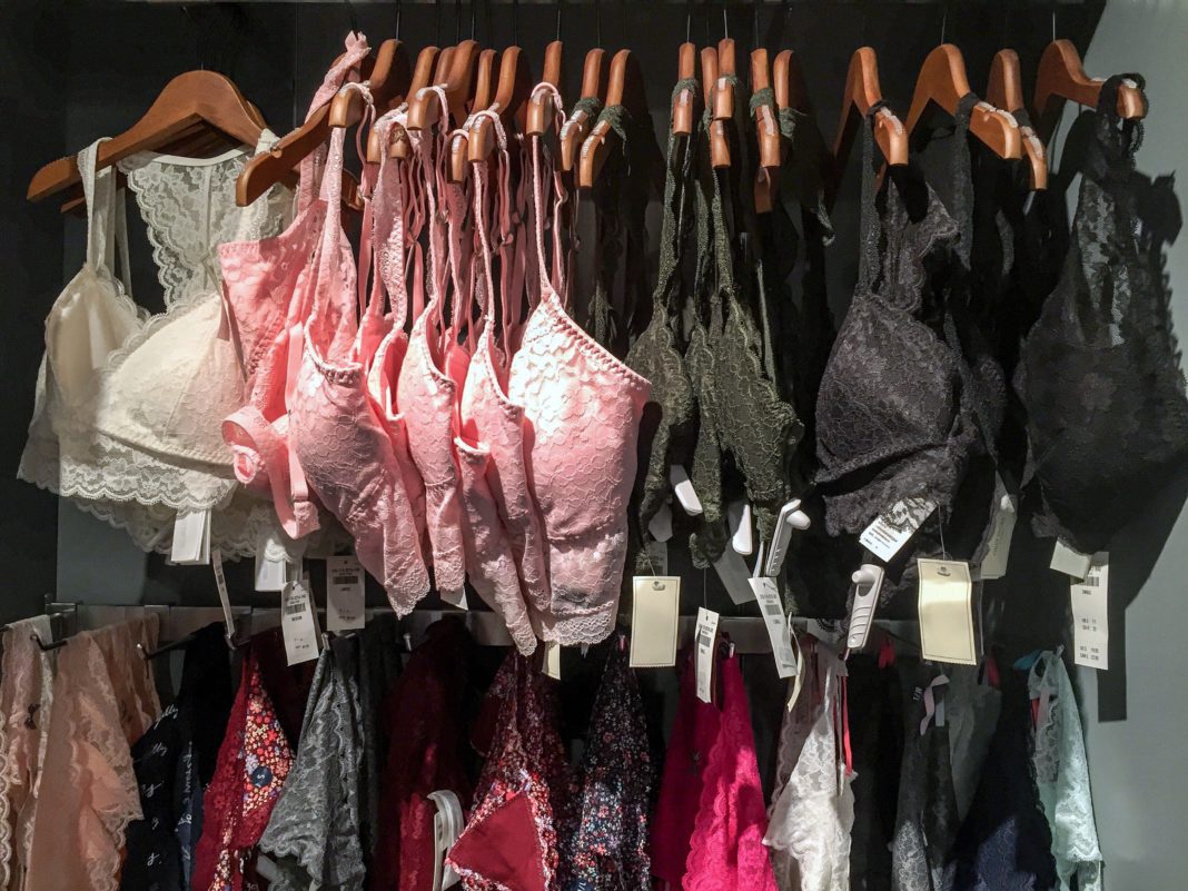 Bras hanging from clothes hangers on a store clothes rail